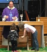 children playing round the altar while holy communion is being celebrated