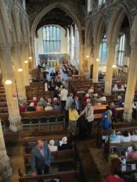Church interior showing a variety of people coming to a service